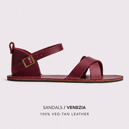 Marsala | Flat leather sandals with ankle straps and debossed PLG three tree logo in soles, shown on a light gray background with text below reading 'SANDALS / VENEZIA' and '100% VEG-TAN LEATHER'.
