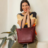 Cognac Zipper | Model wearing larger leather tote bag with sturdy bridle handles and front pocket