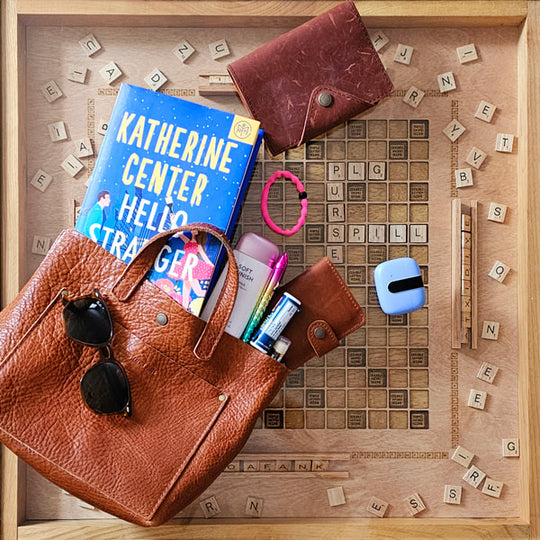 Mini Crossbody Tote with items on a wooden surface with scrabble letters
