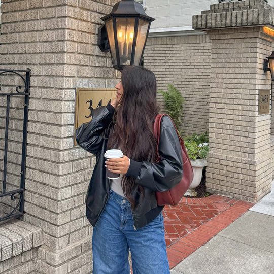 person holding a coffee cup with a Madison Shoulder Bag