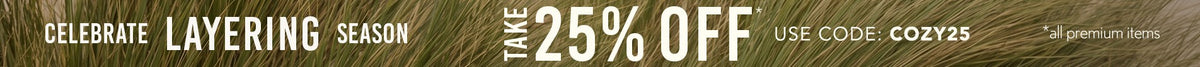 A tall grassy background with Text: Celebrate Layering season. Take 25% off* | Use Code: COZY25 *all premium items.