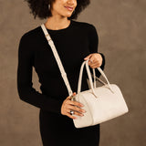 Pebbled Bone Oversized | Model holding mini duffle shaped handbag with crossbody strap