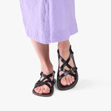 Nero | Person wearing strappy leather sandals with two buckle accents