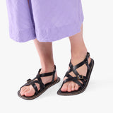 Nero | Person wearing strappy leather sandals with two buckle accents
