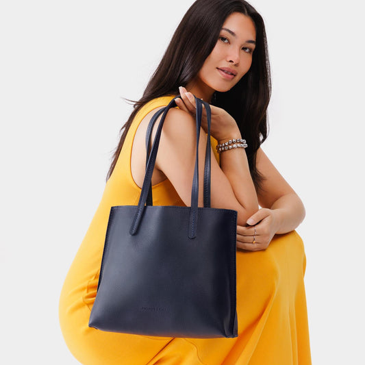 Night Owl*Medium | Model holding leather tote bag with interior snap key loop