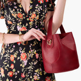 Chili Red Large | Model holding symmetrical bucket bag with handle, latch closure, and removable crossbody strap