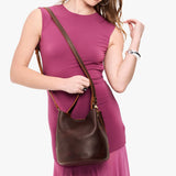 Coldbrew Large | Model wearing symmetrical bucket bag with handle, latch closure, and removable crossbody strap