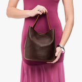 Coldbrew Large | Model holding symmetrical bucket bag with handle, latch closure, and removable crossbody strap