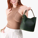 Evergreen Large | Model holding symmetrical bucket bag with handle, latch closure, and removable crossbody strap