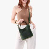 Evergreen Large | Model holding symmetrical bucket bag with handle, latch closure, and removable crossbody strap