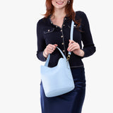 Skyway Large | Model holding symmetrical bucket bag with handle, latch closure, and removable crossbody strap