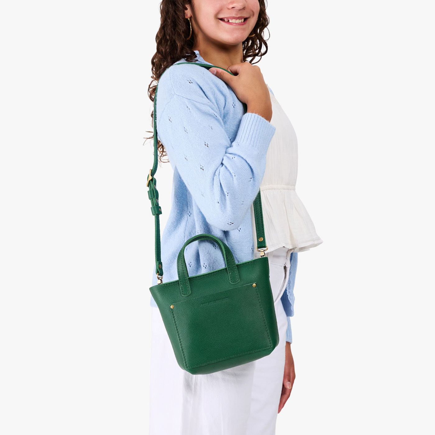 Bacalar | A young model wearing a petite crossbody tote bag with zipper closure and front pocket