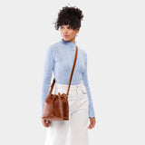 Nutmeg Small | Model wearing slouchy crossbody bag with drawstring closure