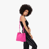 Royalty | Model wearing a symmetrical bucket bag with latch closure and removable crossbody strap