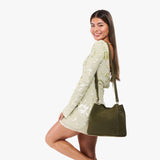 Verdant | Model wearing a symmetrical bucket bag with latch closure and removable crossbody strap