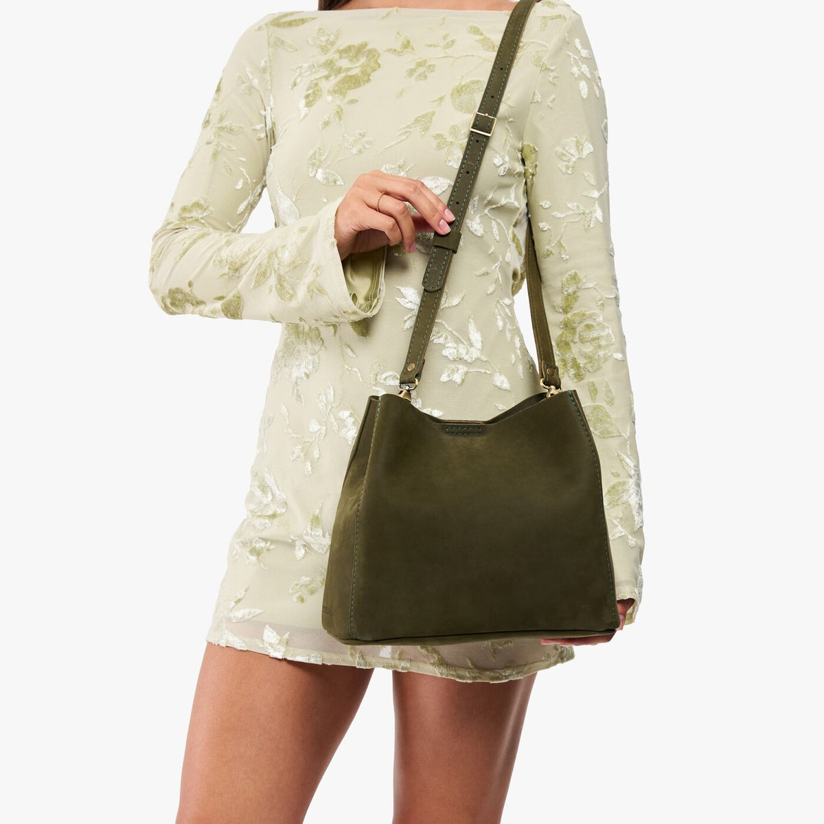 Verdant | Model wearing a symmetrical bucket bag with latch closure and removable crossbody strap