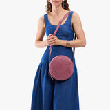 Hollyhock | Model wearing a large circle shaped crossbody bag with top zipper