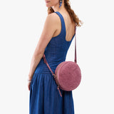 Hollyhock | Model wearing a large circle shaped crossbody bag with top zipper