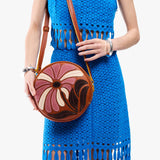 Wildflower Sienna Large | Model holding circle shaped crossbody bag with top zipper