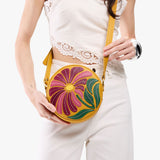 Wildflower Sunshine Small | Model holding circle shaped crossbody bag with top zipper