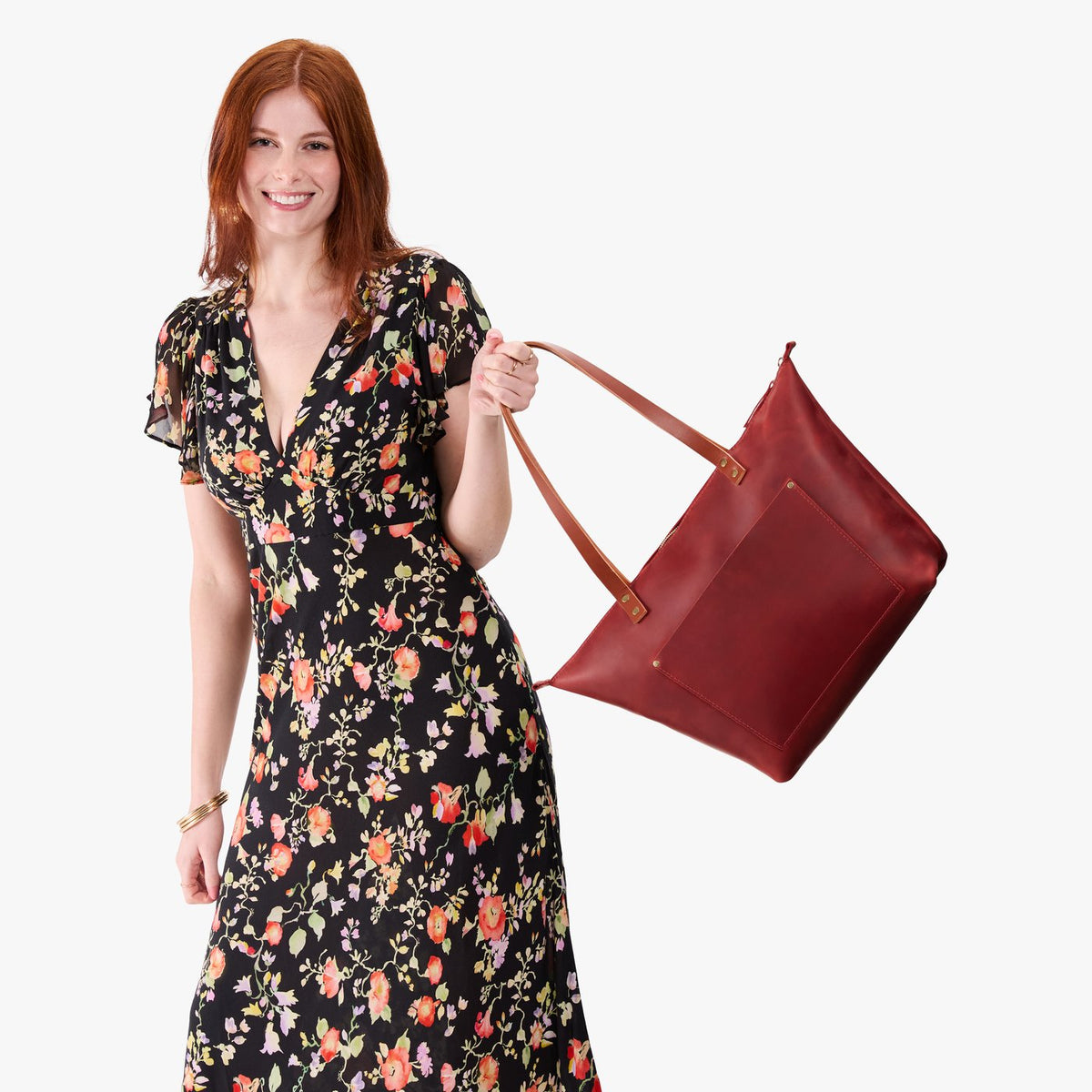 Phoenix*Zipper | Model holding large leather tote bag with sturdy bridle handles and front pocket