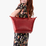 Phoenix Zipper | Model holding large leather tote bag with sturdy bridle handles and front pocket