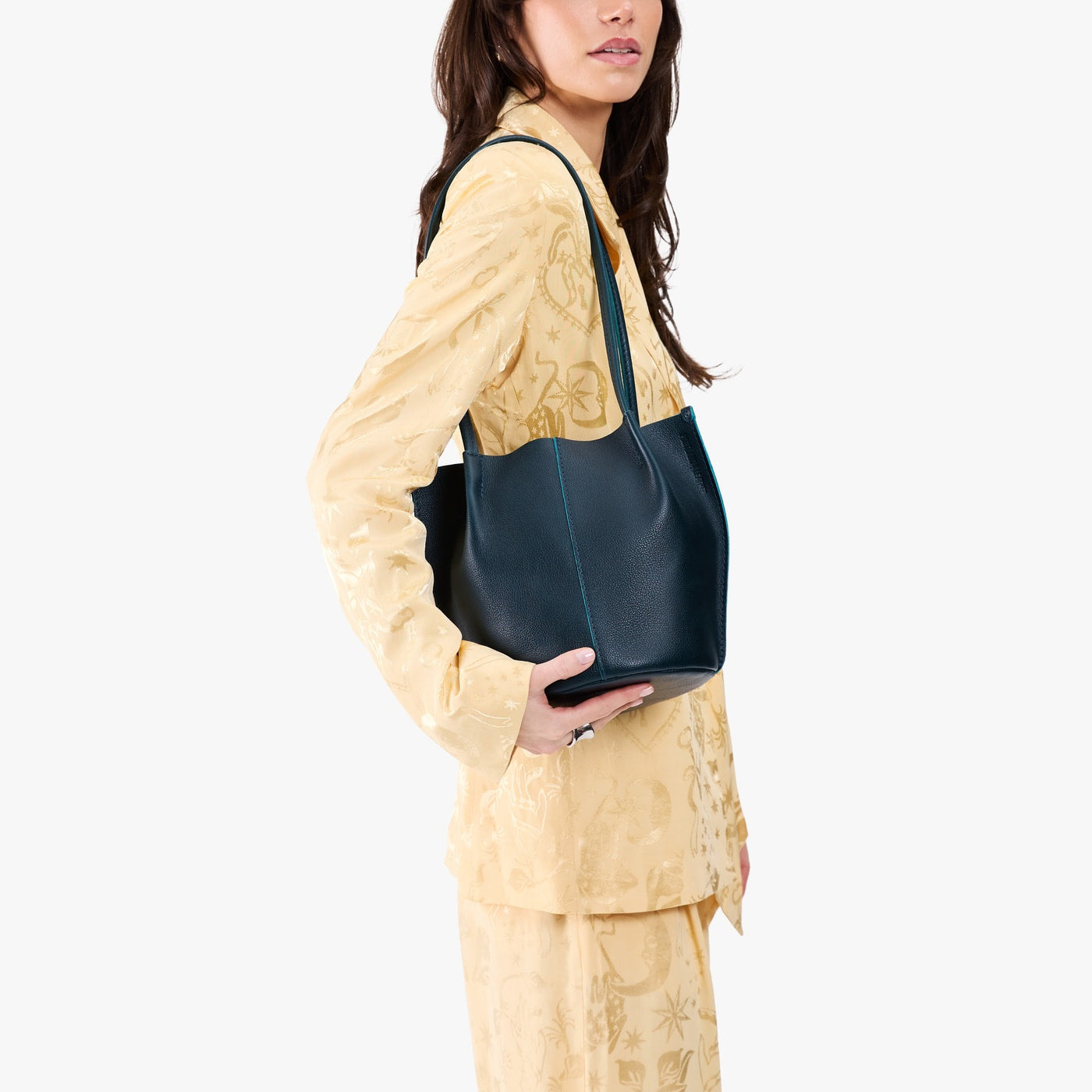 Boreal*Classic | Model wearing matching light yellow shirt and trousers carrying petite bucket shaped tote bag with matching leather handles