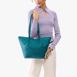 Aquarius Large | Model wearing lavender sweater and white pants carrying wide bucket shaped tote bag with matching leather handles