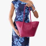 Cosmo Large | Model wearing blue floral patterned dress holding wide bucket shaped tote bag with matching leather handles