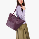 Plum Oversized | Model holding a  leather tote bag 