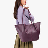 Plum Oversized | Model holding extra wide bucket shaped tote bag with matching leather handles