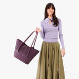 Plum Oversized | Model holding extra wide bucket shaped tote bag with matching leather handles
