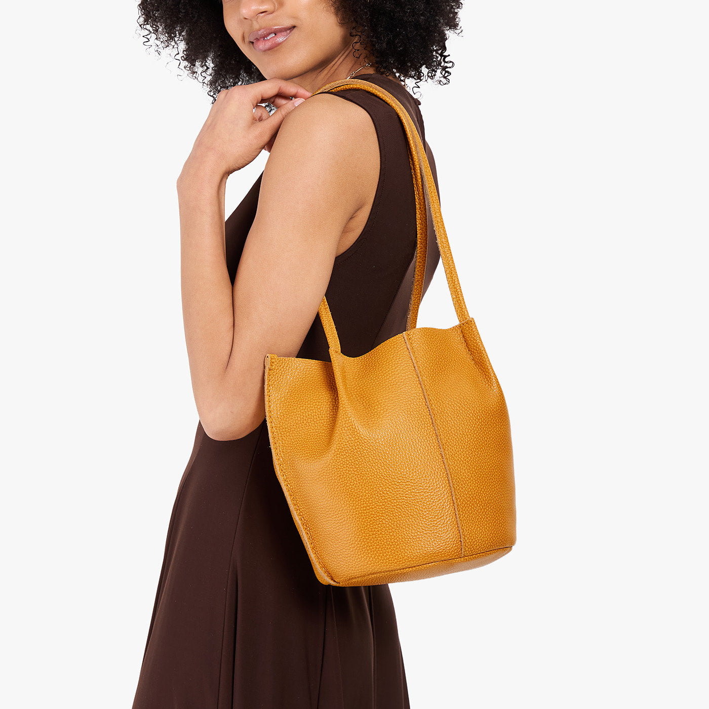 Sunshine*Classic | Model wearing dark brown dress carrying petite bucket shaped tote bag with matching leather handles