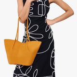 Sunshine Large | Model wearing black dress and carrying wide bucket shaped tote bag with matching leather handles