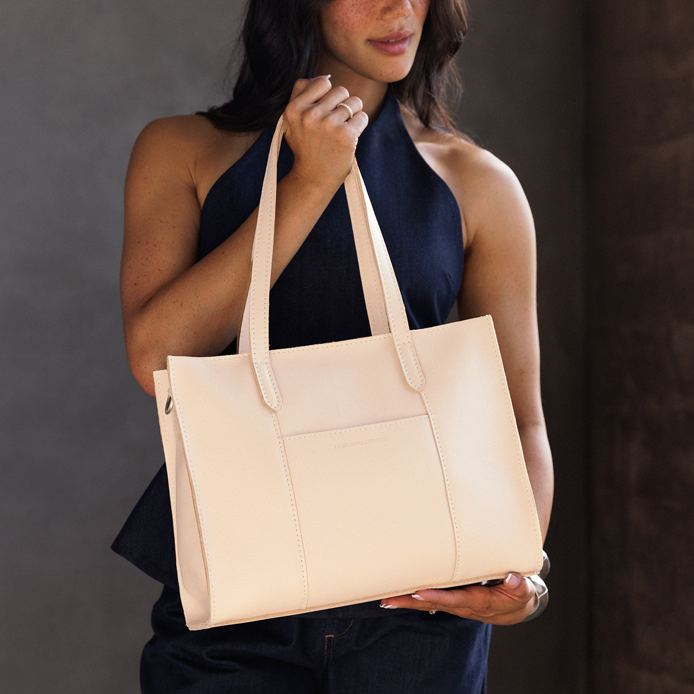 Moonflower*East/West | Model wearing structured wide tote bag with overlapping panels and crossbody strap