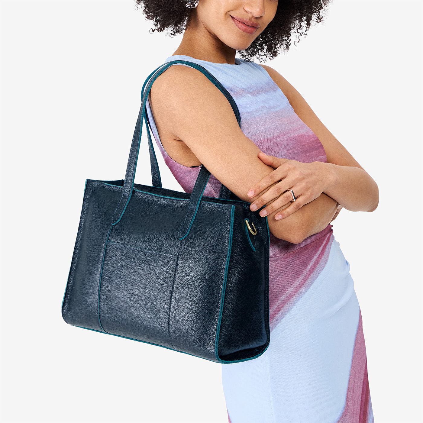 Boreal*East/West | Model holding structured wide tote bag with overlapping panels and crossbody strap