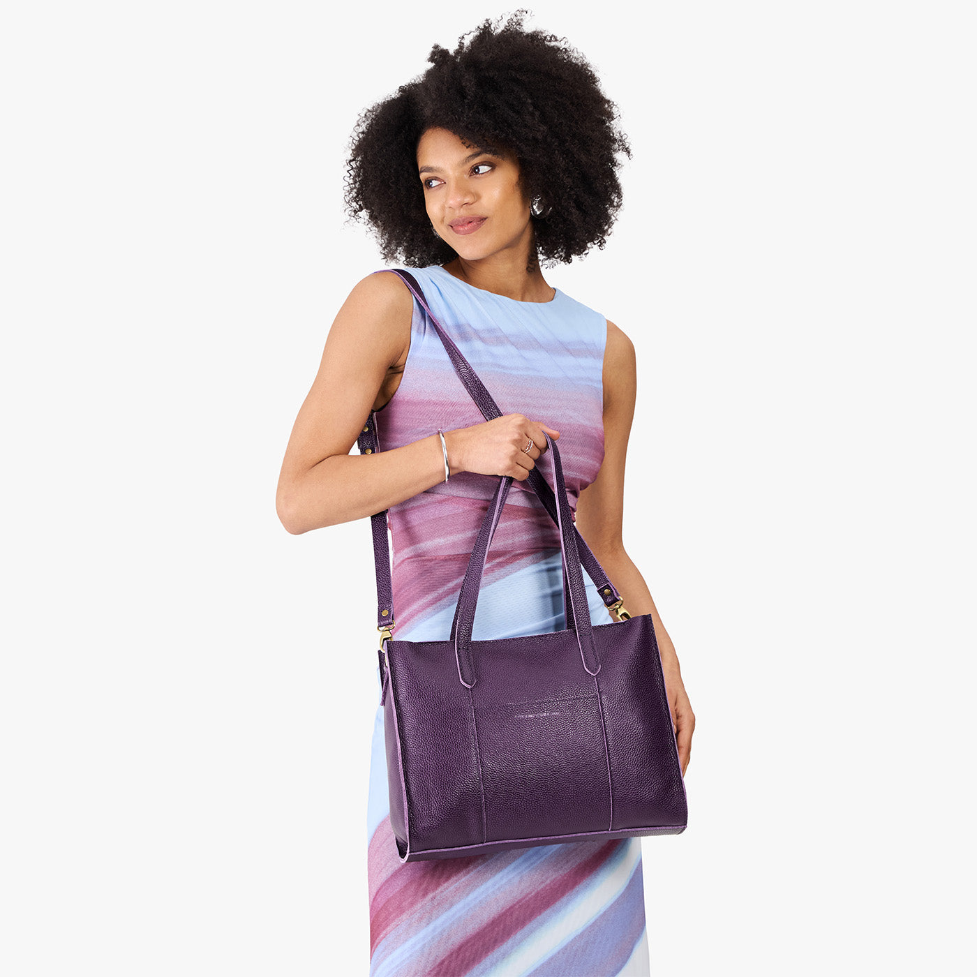 Empire*East/West | Model holding structured wide tote bag with overlapping panels and crossbody strap