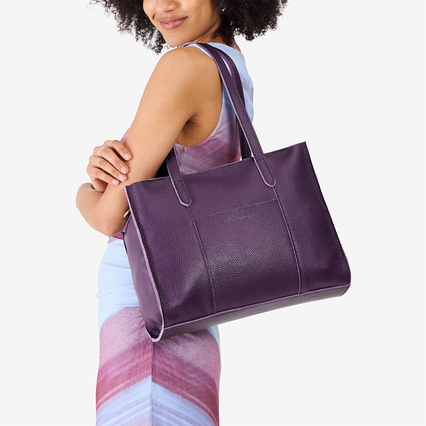 Empire*East/West | Model holding structured wide tote bag with overlapping panels and crossbody strap