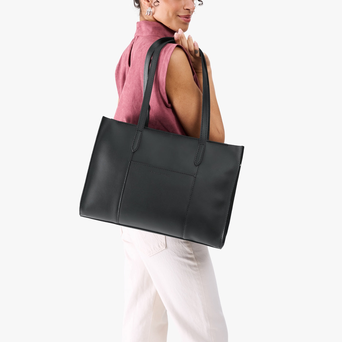 Black*Oversized East/West | Model holding structured wide tote bag with overlapping panels and crossbody strap