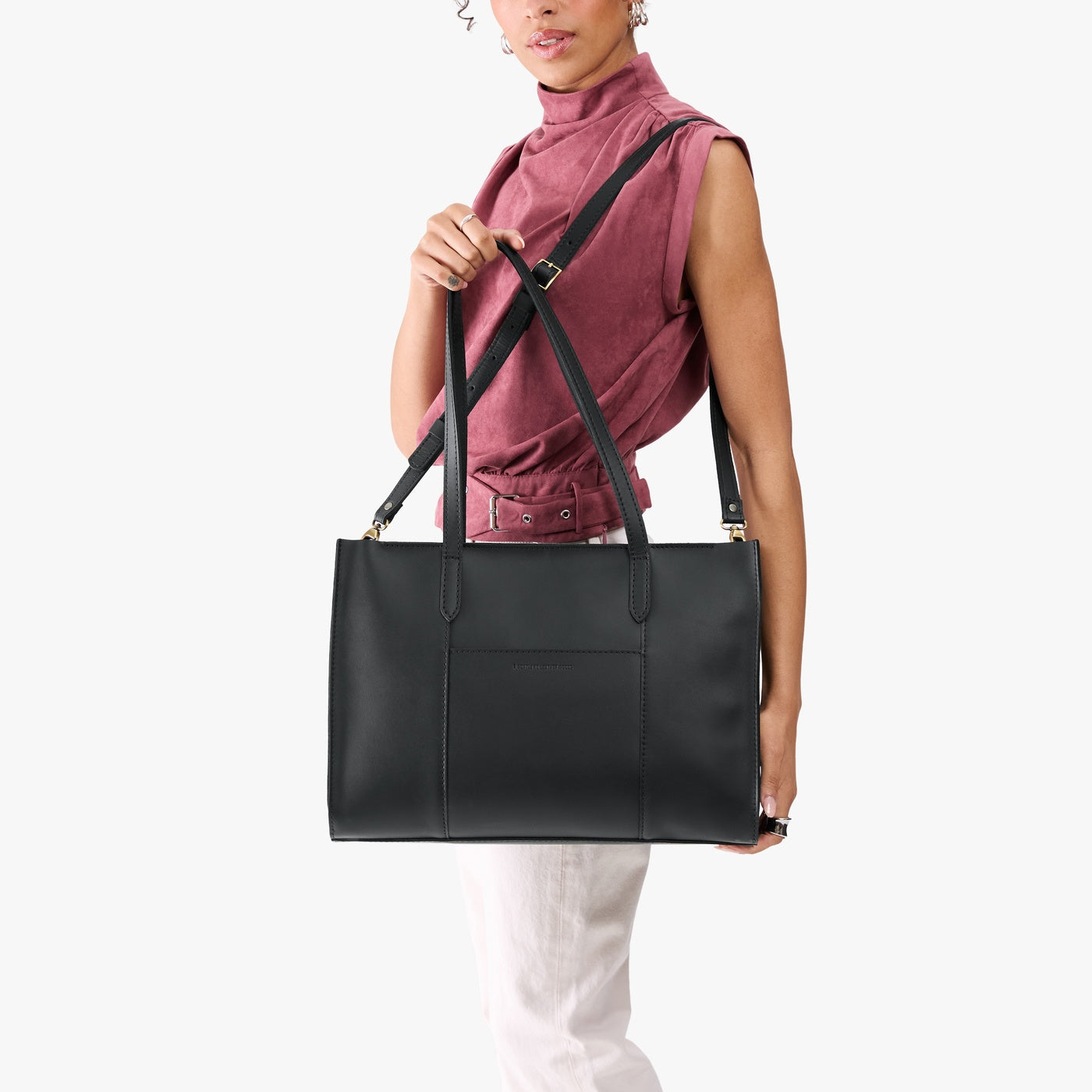 Black*Oversized East/West | Model holding structured wide tote bag with overlapping panels and crossbody strap