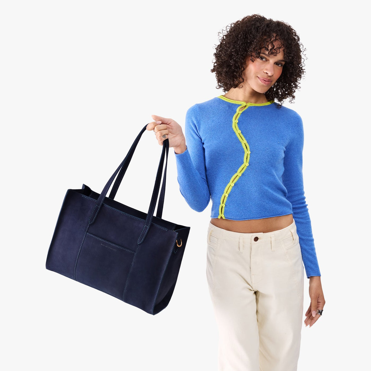 Velvet Blue*Oversized East/West | Model holding structured wide tote bag with overlapping panels and crossbody strap