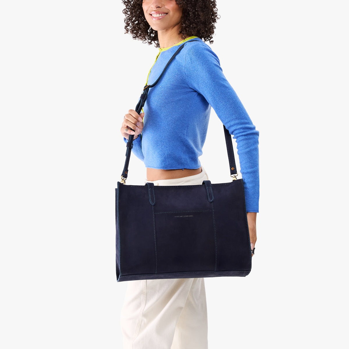 Velvet Blue*Oversized East/West | Model holding structured wide tote bag with overlapping panels and crossbody strap