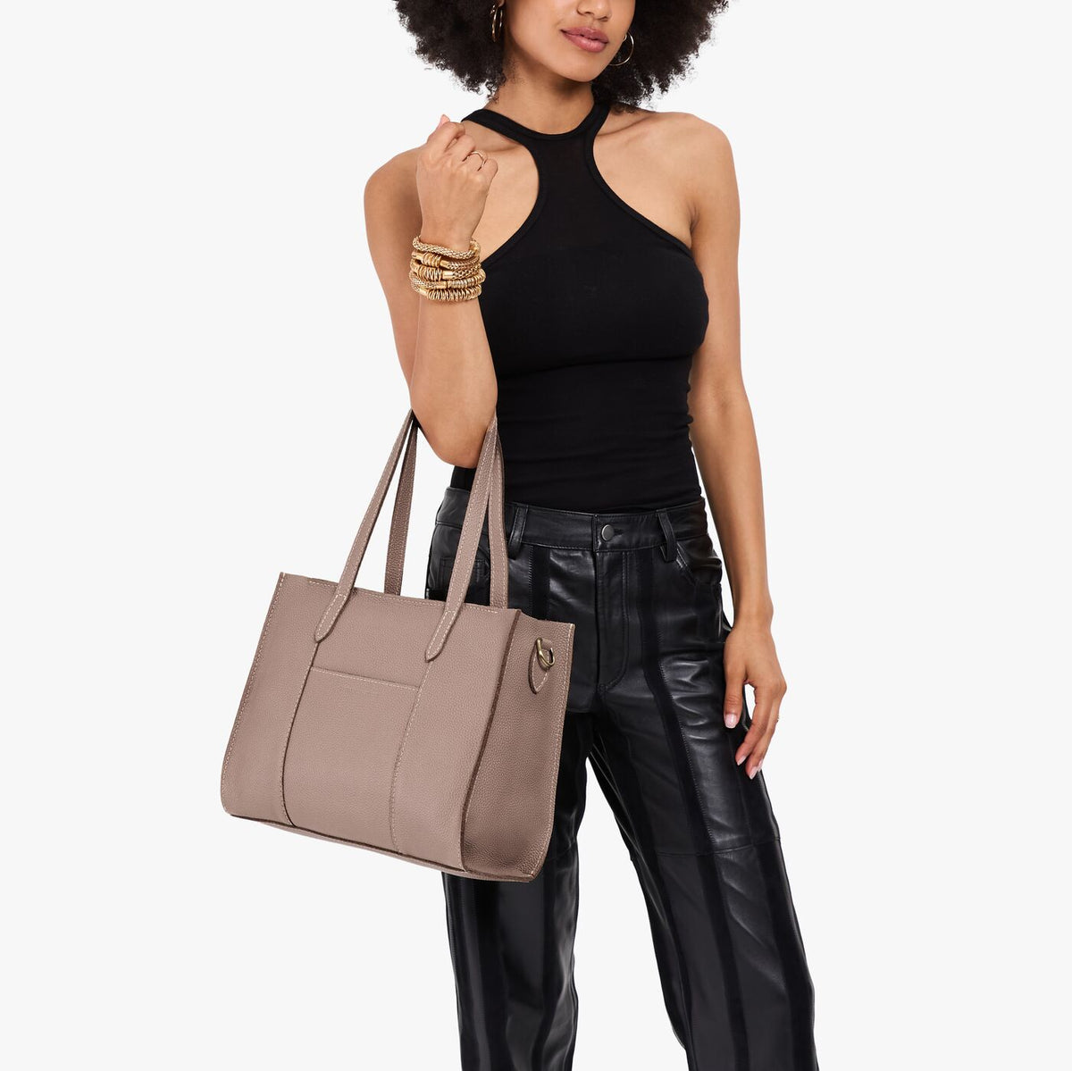Sparrow*East/West | Model holding structured wide tote bag with overlapping panels and crossbody strap
