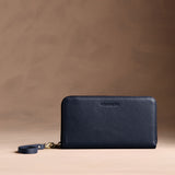 Anchor Blue | Full zip around wallet with a strap on a brown background
