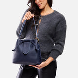 Cobalt Large | Model holding symmetrical leather bag with leather drawstring closure and adjustable shoulder strap