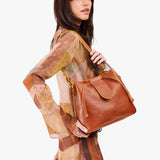 Sienna Large | Model holding symmetrical leather bag with leather drawstring closure and adjustable shoulder strap