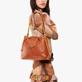 Sienna Large | Model holding symmetrical leather bag with leather drawstring closure and adjustable shoulder strap