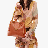 Sienna Large | Model holding symmetrical leather bag with leather drawstring closure and adjustable shoulder strap