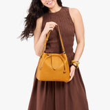 Sunshine Large | Model holding symmetrical leather bag with leather drawstring closure and adjustable shoulder strap