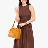 Sunshine Large | Model holding symmetrical leather bag with leather drawstring closure and adjustable shoulder strap